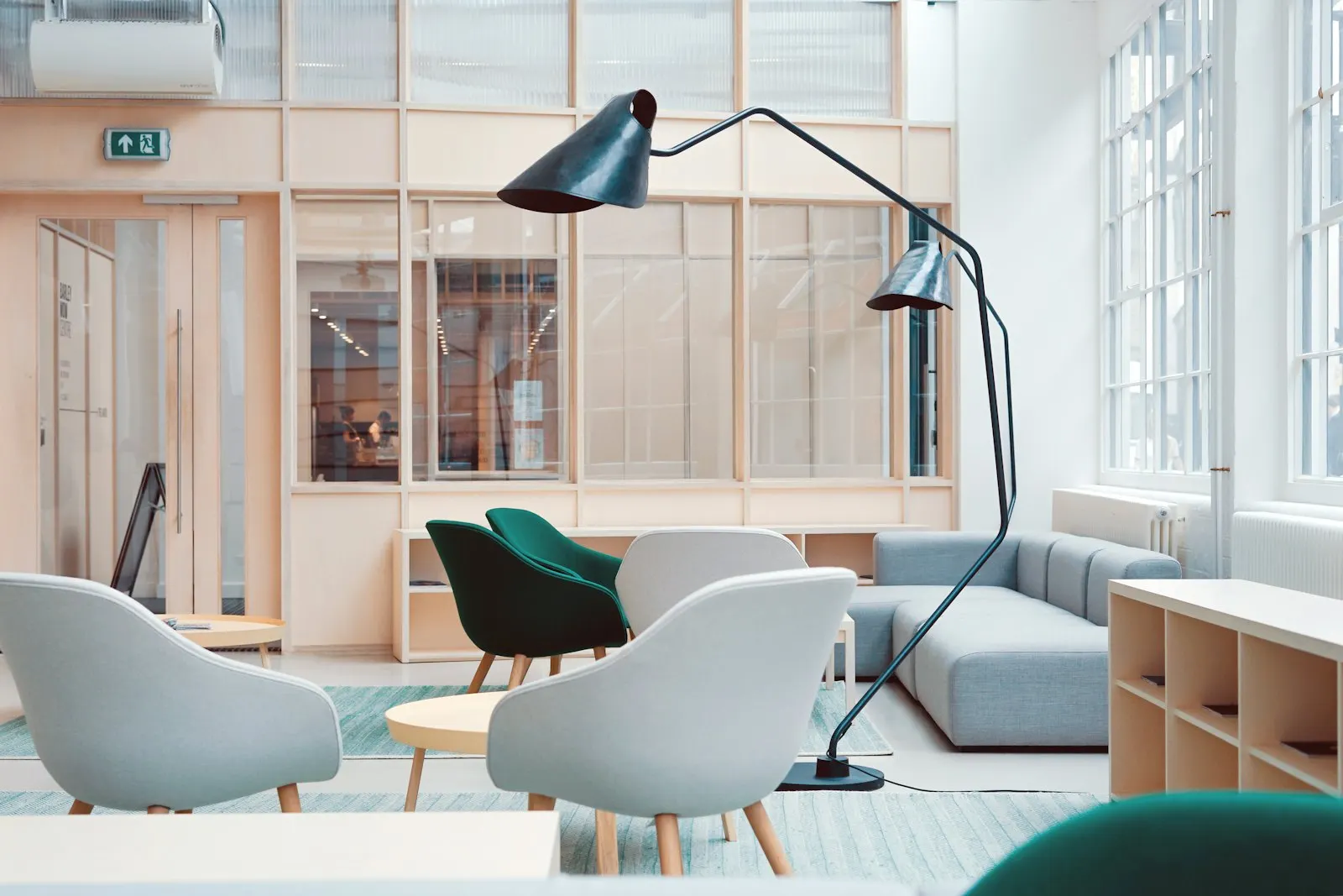 Office lounge with wood slat dividers, soft seating and biophilic planting