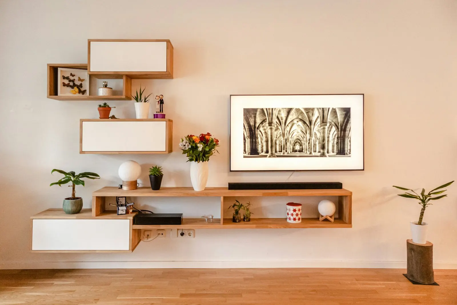 Feature wall with floating wooden shelves, warm spotlighting and a styled console below