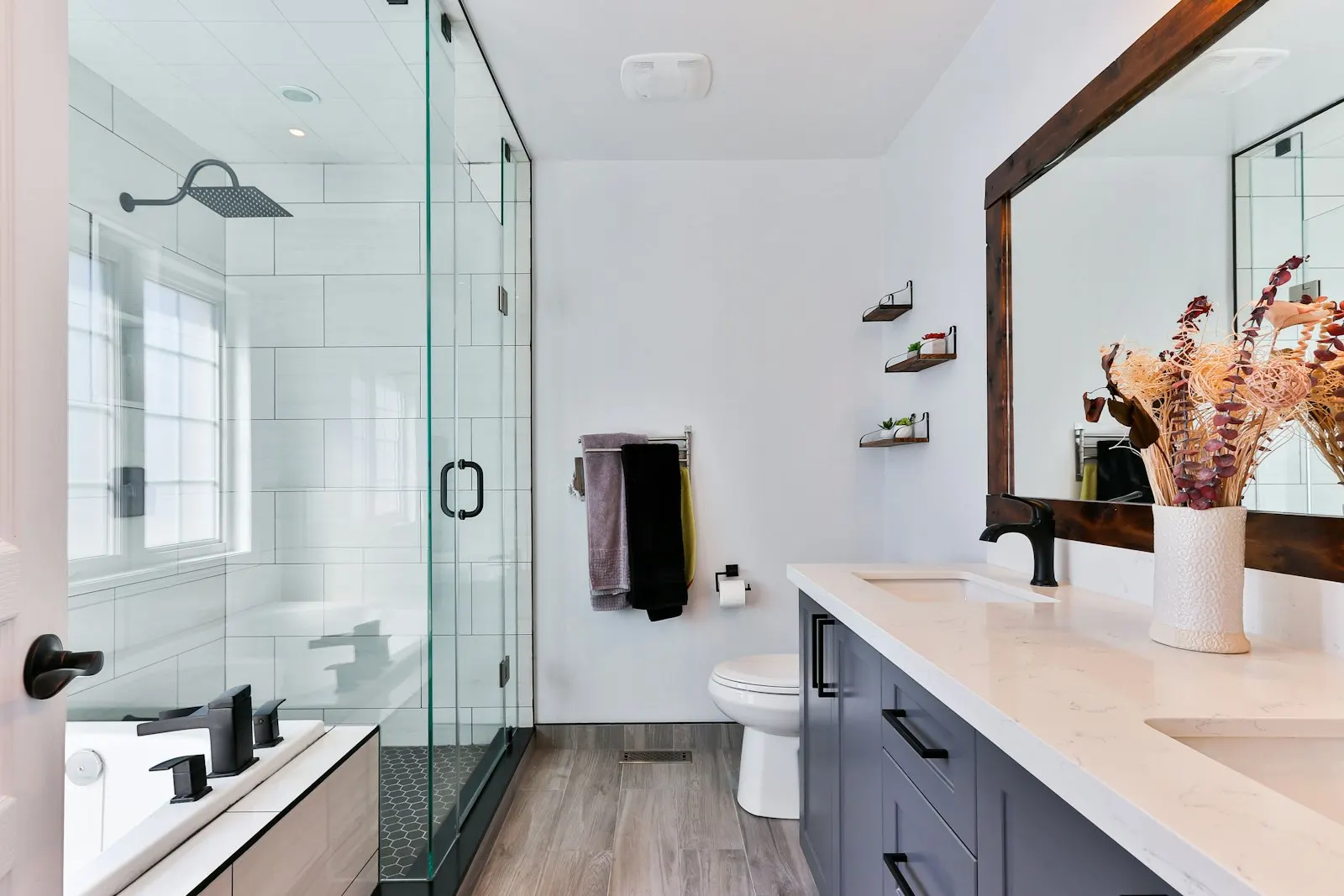 Bathroom with a glass-enclosed shower, floating vanity and full-height tiling