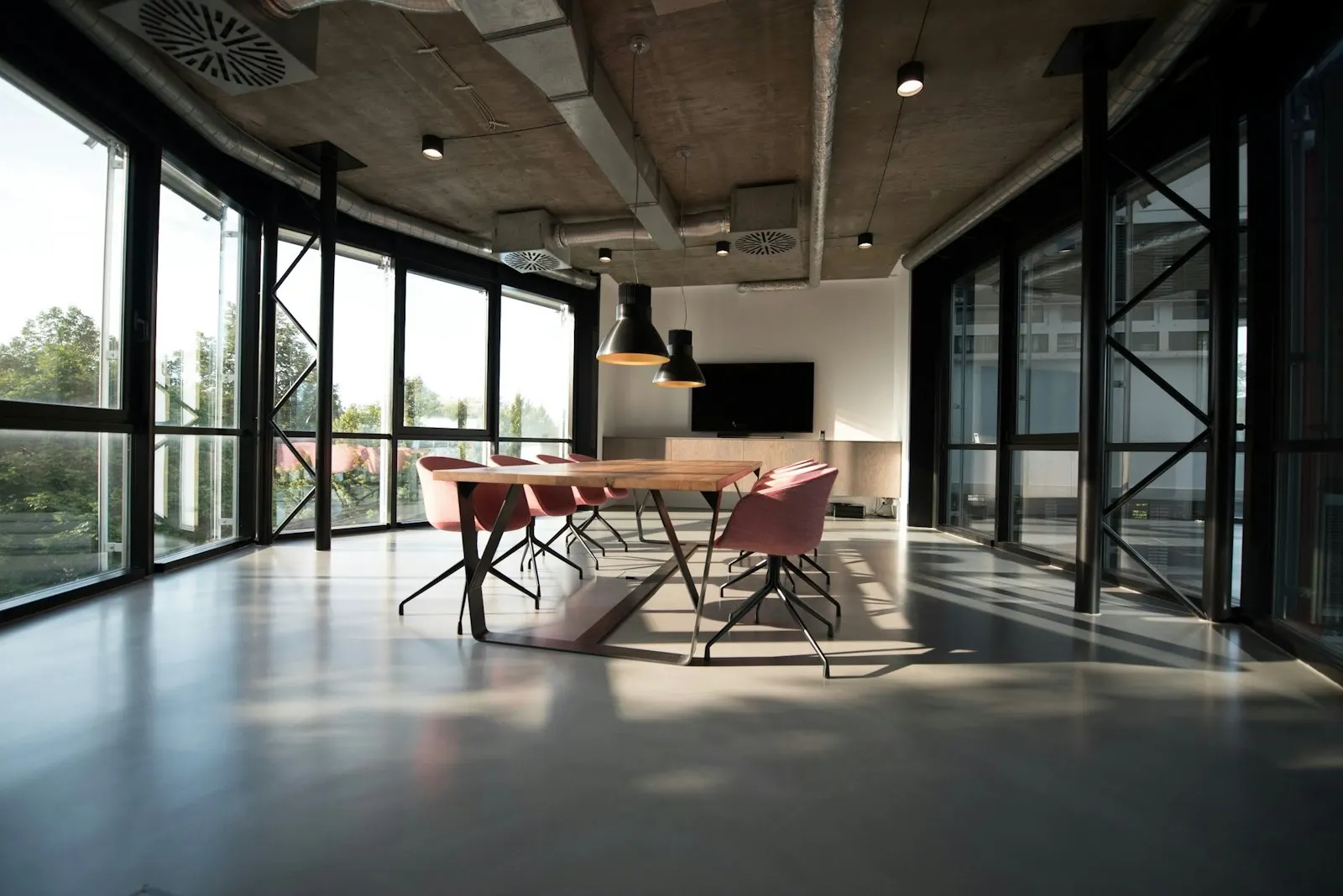 Boardroom with full-height glazing, a long meeting table and ergonomic chairs